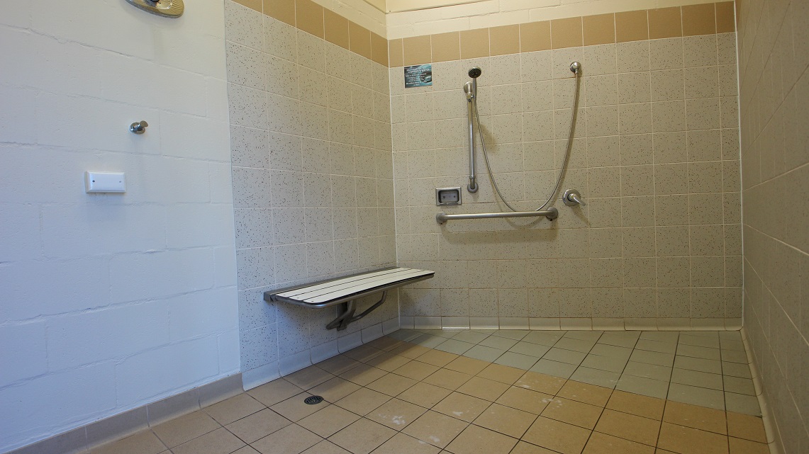 The shower area inside the bathroom of the open-air aquatic area inside Bribie Island. The bathroom is larger than usual for a pool facility. The shower area stands out for its ample space and good upkeep. In the corner near the shower faucet, there is a small metallic chair available for use. The shower area inside the bathroom of the open-air aquatic area inside Bribie Island. The bathroom is larger than usual for a pool facility. The shower area stands out for its ample space and good upkeep. In the corner near the shower faucet, there is a small metallic chair available for use.