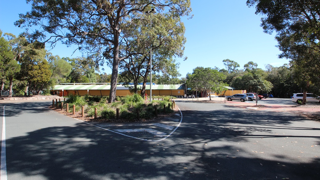 A plain driveway through the Bribie Island Aquatic and Leisure Centre. It is surrounded by beautiful bushland and forest, creating a serene atmosphere. You can spot a street light nearby, as well as two signs that probably look quite alike. The driveway is impeccably maintained, and the broken white lines along the road are clearly visible. A plain driveway through the Bribie Island Aquatic and Leisure Centre. It is surrounded by beautiful bushland and forest, creating a serene atmosphere. You can spot a street light nearby, as well as two signs that probably look quite alike. The driveway is impeccably maintained, and the broken white lines along the road are clearly visible.