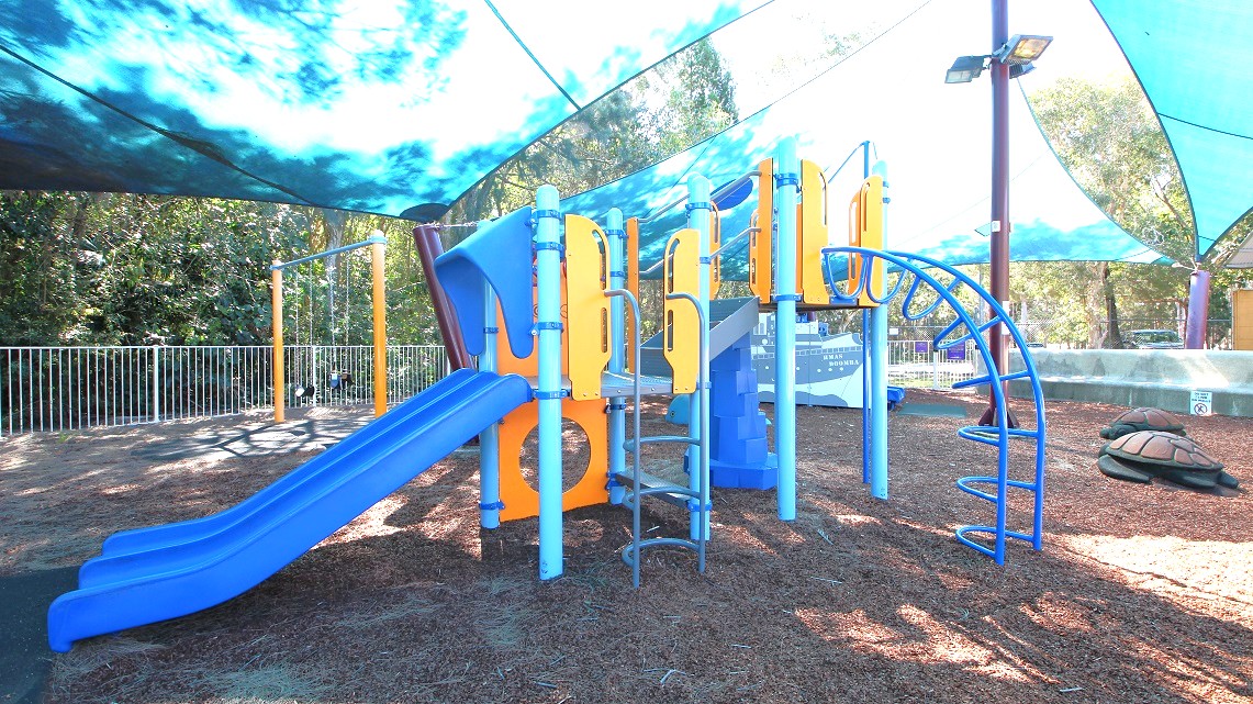 A closer look at the playground area within the pool. It's a spacious space filled with fun activities like slides, swings, and playful decorations such as turtles and a ship. All the playground equipment is brightly colored with shades of blue and orange, adding a vibrant atmosphere. For safety, there are fences surrounding the area, separating it from the thick forests outside. A closer look at the playground area within the pool. It's a spacious space filled with fun activities like slides, swings, and playful decorations such as turtles and a ship. All the playground equipment is brightly colored with shades of blue and orange, adding a vibrant atmosphere. For safety, there are fences surrounding the area, separating it from the thick forests outside.
