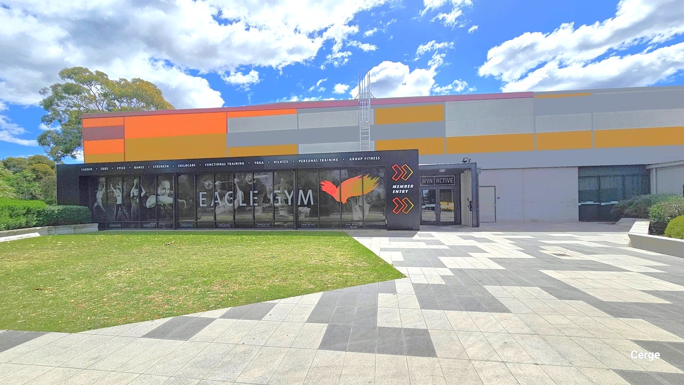 Eagle Gym entrance. The floor area outside of the gym can be differentiated by the polygon-shaped grass section and alternating light and dark grey tiles. The outside wall design of the gym is a combination of a black wall containing a white typeface listing the different gym offers and features and a glass window with an image highlighting several gym equipments as an advertisement. On the right side of the black wall is a yellow-orange outline of arrows with a white Member Entry between them.