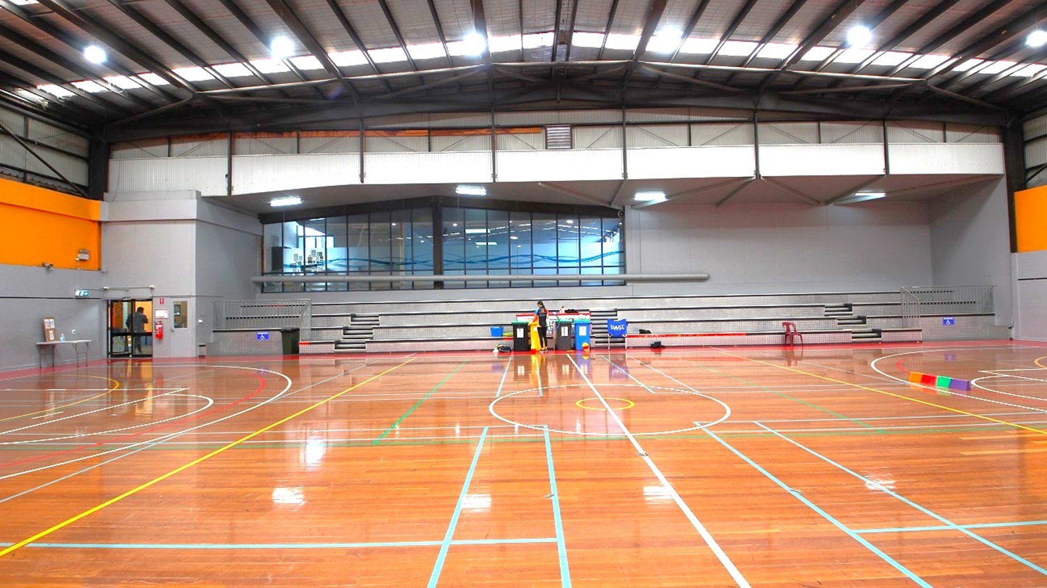At the side of the two courts is a grey stadium with 4 steps that can accommodate at least 100 people. At the edge of the stadium is a metal railing that separates the audience from the players. At the side of the two courts is a grey stadium with 4 steps that can accommodate at least 100 people. At the edge of the stadium is a metal railing that separates the audience from the players.