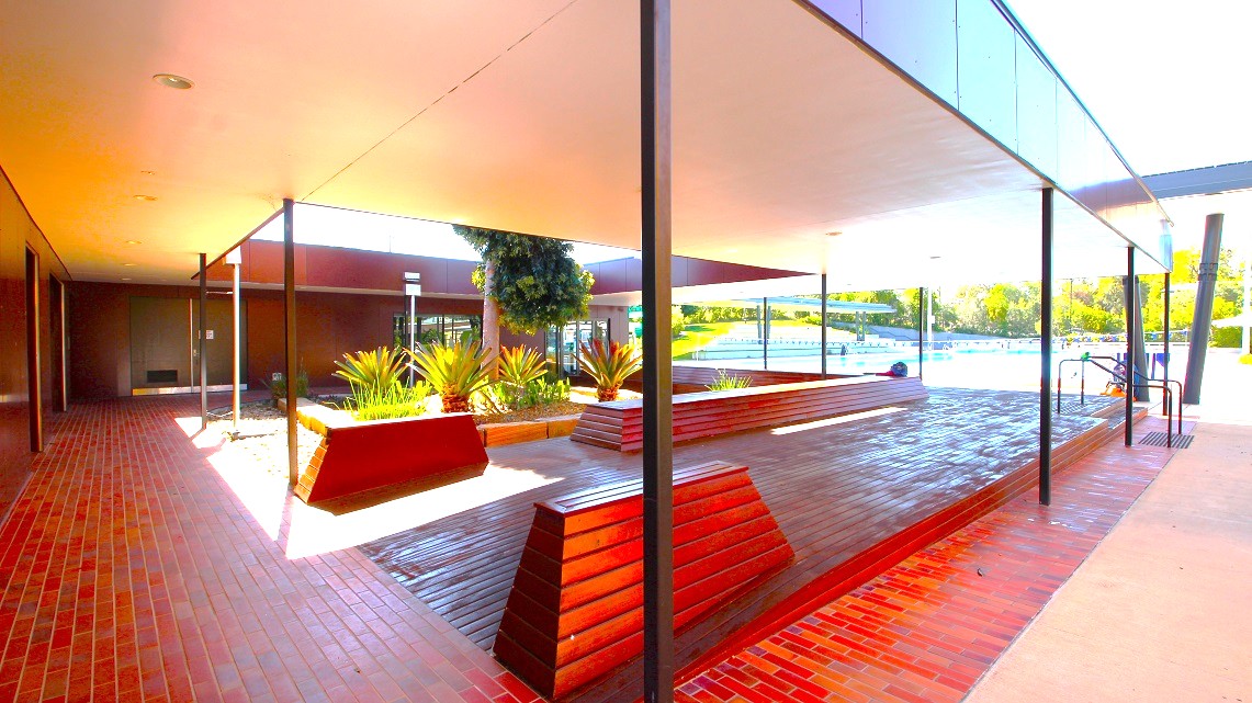 A closer look at the pathways around the veranda. There is seating visible on the spacious open verandas that wrap around a central garden area. Also, this entire section is encompassed by additional gardens. A handrail is clearly positioned in the right corner for safety. Furthermore, fluorescent lighting is prominently installed above the left-side pathway of the veranda, ensuring well-lit conditions. A closer look at the pathways around the veranda. There is seating visible on the spacious open verandas that wrap around a central garden area. Also, this entire section is encompassed by additional gardens. A handrail is clearly positioned in the right corner for safety. Furthermore, fluorescent lighting is prominently installed above the left-side pathway of the veranda, ensuring well-lit conditions.