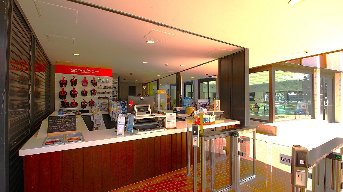 A closer look at the reception area. Inside the reception area, fluorescent lighting floods the space, ensuring ample illumination. You'll find essential items like swimming slippers and backup swimwear readily available, making it convenient for visitors. Before entering the interior of the ARC, there are noticeable metal grill doors that add to the modern and secure atmosphere of the facility. A closer look at the reception area. Inside the reception area, fluorescent lighting floods the space, ensuring ample illumination. You'll find essential items like swimming slippers and backup swimwear readily available, making it convenient for visitors. Before entering the interior of the ARC, there are noticeable metal grill doors that add to the modern and secure atmosphere of the facility.