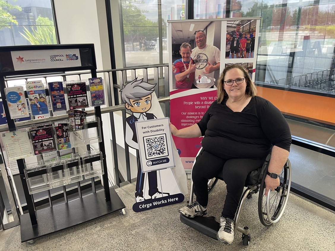 A woman in a wheelchair sits beside a display at a store. A woman in a wheelchair sits beside a display at a store.