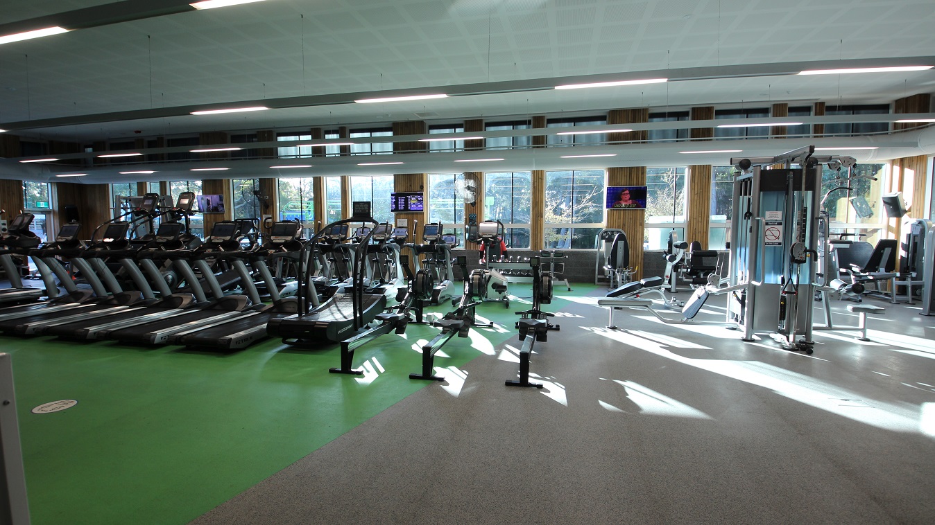 Inside look at the Health Club room containing several pieces of cardiovascular equipment. The floor is divided into green and grey areas. Several treadmills are placed on the green floor. The room has glass walls with an outlook over the forest and trees which creates a natural ambience. Inside look at the Health Club room containing several pieces of cardiovascular equipment. The floor is divided into green and grey areas. Several treadmills are placed on the green floor. The room has glass walls with an outlook over the forest and trees which creates a natural ambience.