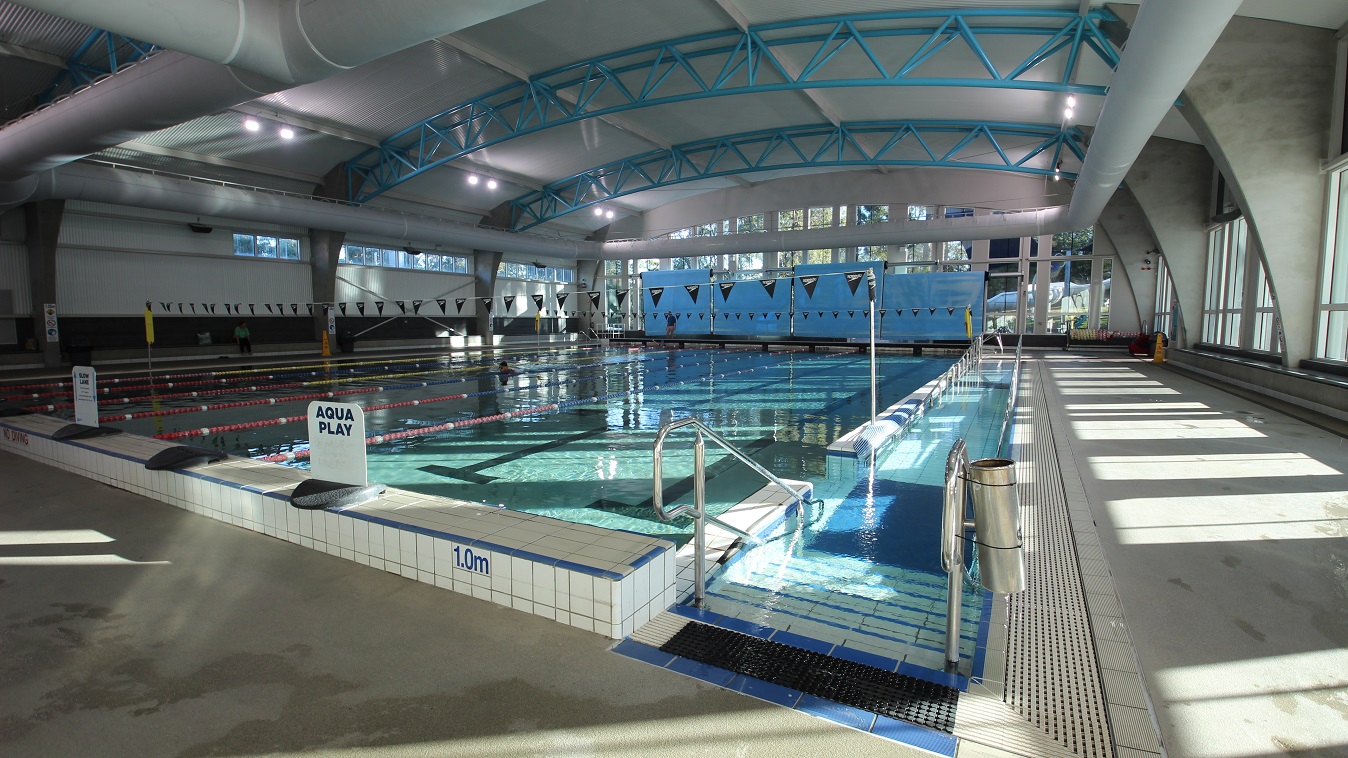 Right side view of the 8-lane 25-meter pool. The entry point to the pool is by the entrance ramp and staircase. On top of the elevated section is the Aqua Play signboard. The pool lanes are separated by red and yellow floating lane ropes, while the others are separated by red and blue lane ropes. Right side view of the 8-lane 25-meter pool. The entry point to the pool is by the entrance ramp and staircase. On top of the elevated section is the Aqua Play signboard. The pool lanes are separated by red and yellow floating lane ropes, while the others are separated by red and blue lane ropes.