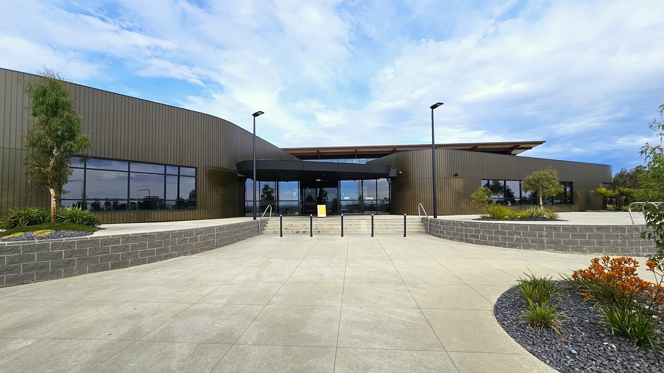 The Stromlo Leisure Centre features a contemporary architectural design, integrating glass, steel, and timber elements. A concrete staircase with handrails and bollards is positioned in the middle. The concourse is adorned with a landscape of plants, trees, and grass. Tall street lights are situated in front of the entrance. The Stromlo Leisure Centre features a contemporary architectural design, integrating glass, steel, and timber elements. A concrete staircase with handrails and bollards is positioned in the middle. The concourse is adorned with a landscape of plants, trees, and grass. Tall street lights are situated in front of the entrance.