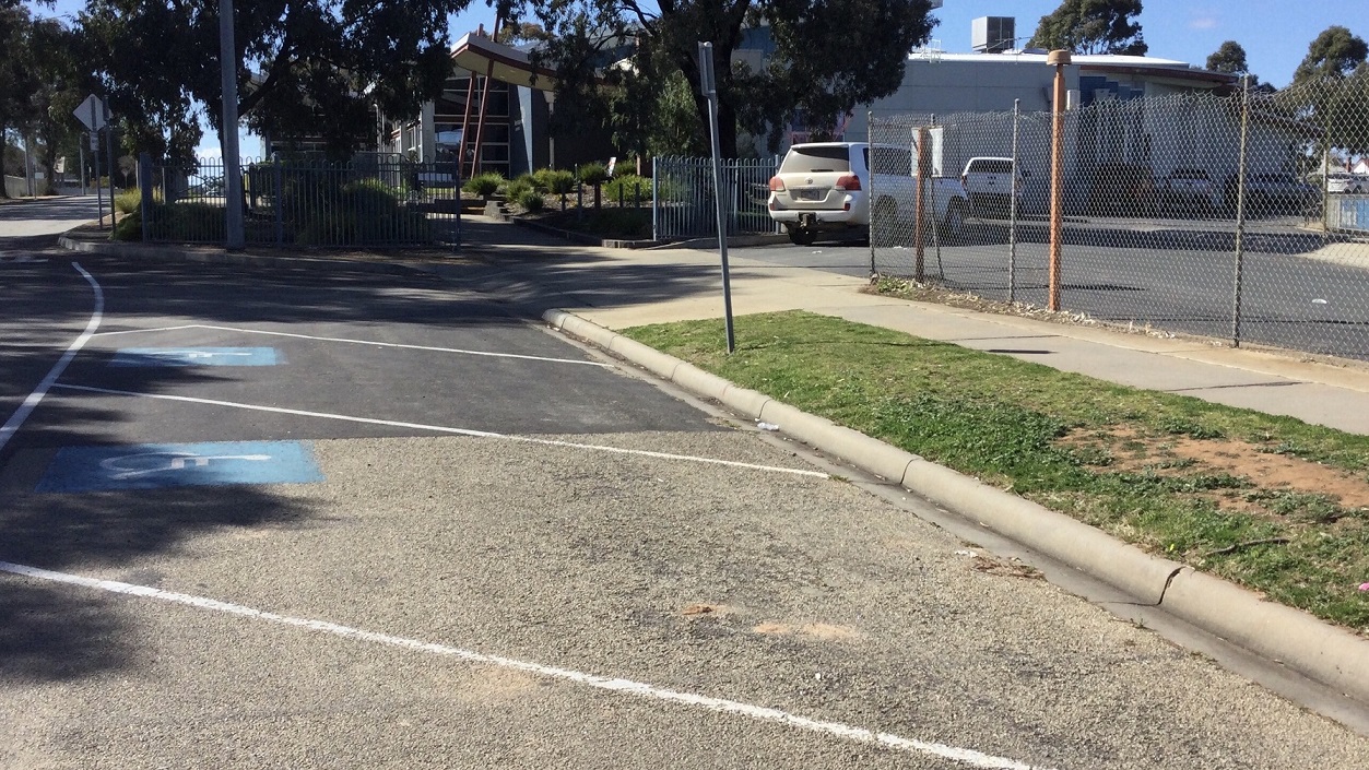In close proximity to the centre’s main entrance is the carpark with accessible parking spaces. There is a chain link fence that serves as the carpark’s facade and a blue gate on its left where cars may enter to park. In front of the wired fence is a white pavement leading to several accessible car spaces. From this view, you will see the centre surrounded by trees. In close proximity to the centre’s main entrance is the carpark with accessible parking spaces. There is a chain link fence that serves as the carpark’s facade and a blue gate on its left where cars may enter to park. In front of the wired fence is a white pavement leading to several accessible car spaces. From this view, you will see the centre surrounded by trees.