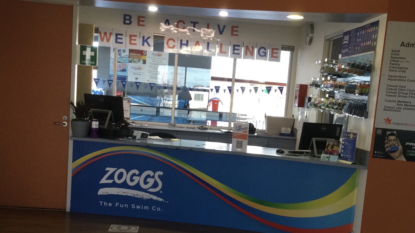 This is a closer look of the centre’s main entrance that has a manual glass door with split panels leading you immediately to a retail offering with product display. The right side of the glass door has a glued ad poster saying “Heighten your health & happiness with your first 100 days free”. It has a picture of a lady that wears a red boxing glove. Opposite the glass door is a white wall and to the left is a glass wall that lets you see the green scenery from the outside. This is a closer look of the centre’s main entrance that has a manual glass door with split panels leading you immediately to a retail offering with product display. The right side of the glass door has a glued ad poster saying “Heighten your health & happiness with your first 100 days free”. It has a picture of a lady that wears a red boxing glove. Opposite the glass door is a white wall and to the left is a glass wall that lets you see the green scenery from the outside.