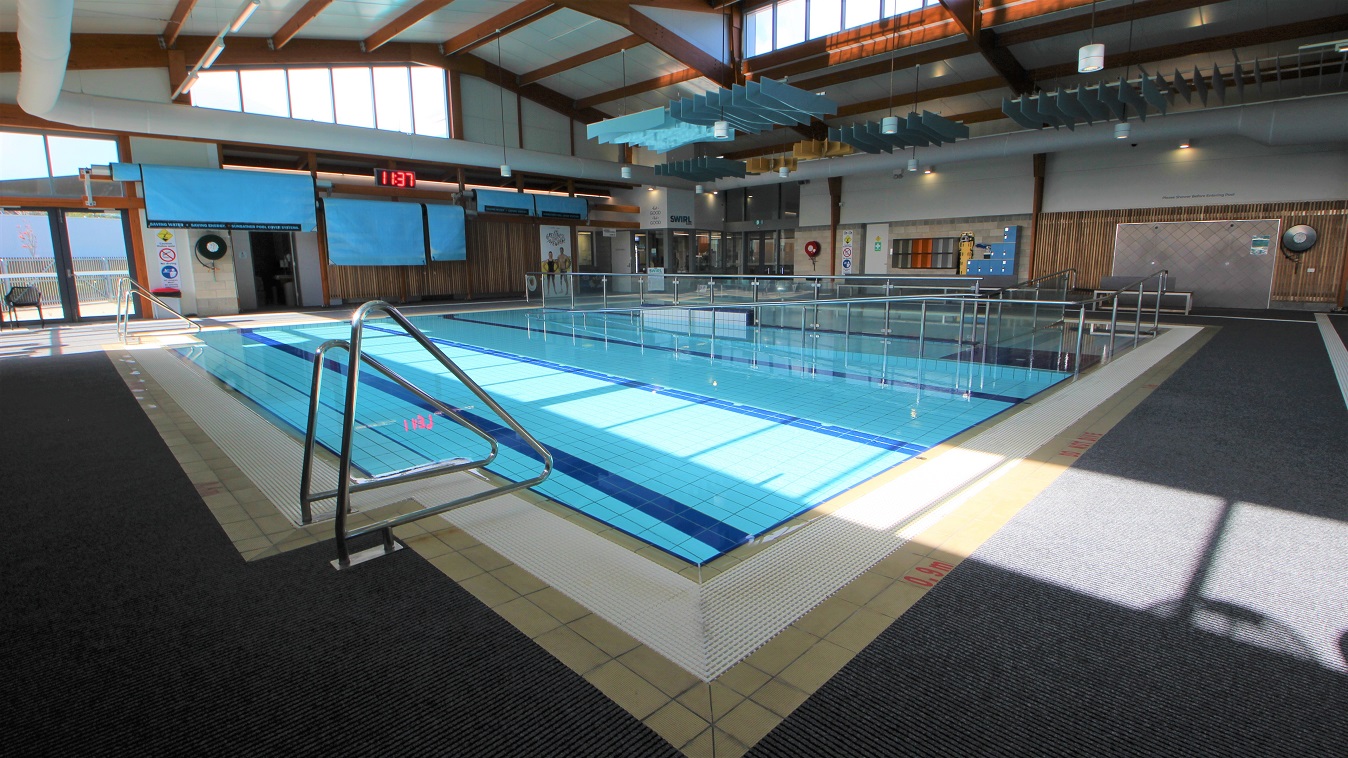 A closer look at the three-lane (6m x 12.5m) program pool that is 0.9m in depth that has a railed entrance ramp. There are two pool ladders on each end of the pool. Seen from this position is a digital clock placed on the upper wall of the facility. Separating the three-lane (6 m x 12.5m) program pool and the shallow pool found near the entrance door is a steel frame with a glass wall. A closer look at the three-lane (6m x 12.5m) program pool that is 0.9m in depth that has a railed entrance ramp. There are two pool ladders on each end of the pool. Seen from this position is a digital clock placed on the upper wall of the facility. Separating the three-lane (6 m x 12.5m) program pool and the shallow pool found near the entrance door is a steel frame with a glass wall.