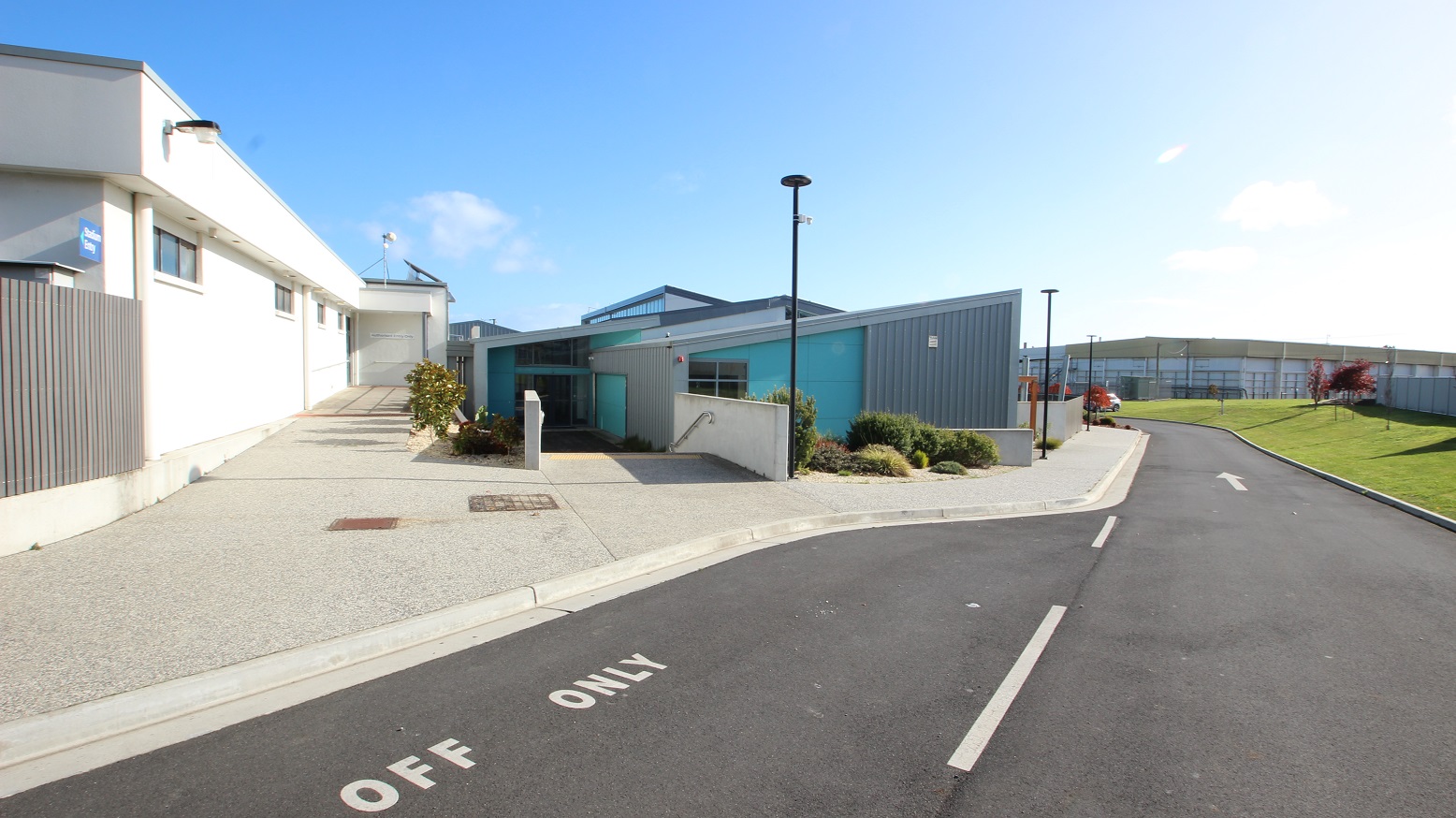Drop-off area of SWIRL. There are two entry points to the facility. One is through a ramp on the left where a white building with a grey fence is located while the other is through a staircase with metal handrails mounted on the hip-length white wall leading to the SWIRL, automatic, double glass door entrance. The facility is white, grey, and light green with an irregular rectangular shape with a pointed edge. Drop-off area of SWIRL. There are two entry points to the facility. One is through a ramp on the left where a white building with a grey fence is located while the other is through a staircase with metal handrails mounted on the hip-length white wall leading to the SWIRL, automatic, double glass door entrance. The facility is white, grey, and light green with an irregular rectangular shape with a pointed edge.