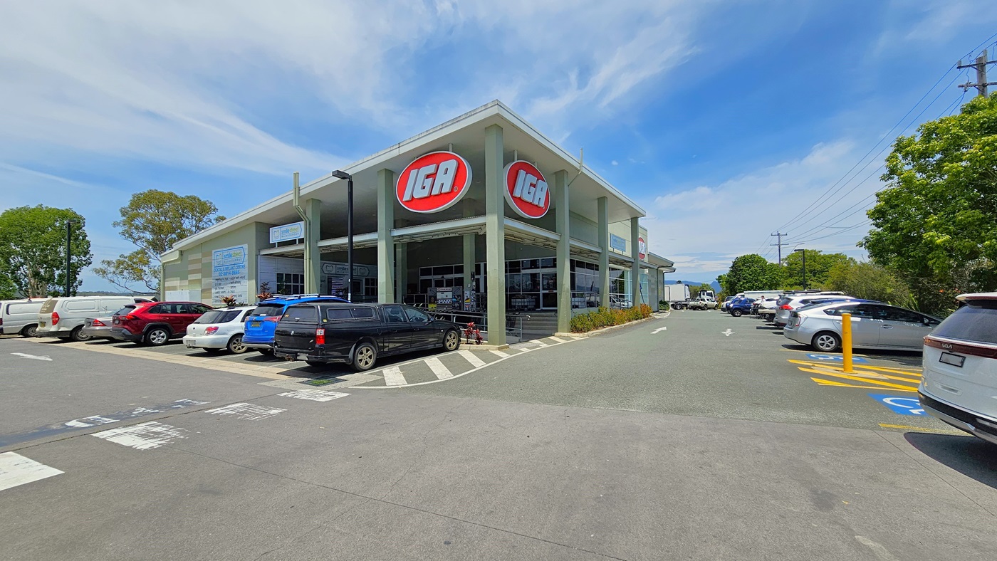 Accessible parking spaces in front and the right side of the nearby road. Cars are visibly parked in an organized manner. On the right, a road pole with lines in yellow hues separates two accessible car parking spaces.. Two huge IGA logos are visibly placed above the entrance of the building. Accessible parking spaces in front and the right side of the nearby road. Cars are visibly parked in an organized manner. On the right, a road pole with lines in yellow hues separates two accessible car parking spaces.. Two huge IGA logos are visibly placed above the entrance of the building.