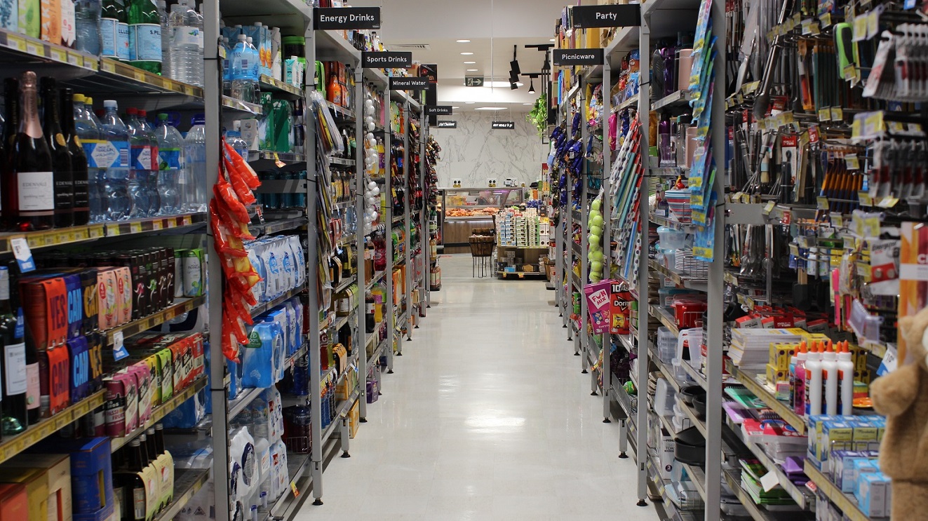 At the left side of this grocery section, there are a variety of drinks such as wine, soda, energy drinks, sports drinks and bottled mineral water. The opposite display rack has the items needed in the party like picnicwares, party hats and decorations. The aisle of this section seems pleasant and clean because of the white and tidy floor. At the left side of this grocery section, there are a variety of drinks such as wine, soda, energy drinks, sports drinks and bottled mineral water. The opposite display rack has the items needed in the party like picnicwares, party hats and decorations. The aisle of this section seems pleasant and clean because of the white and tidy floor.